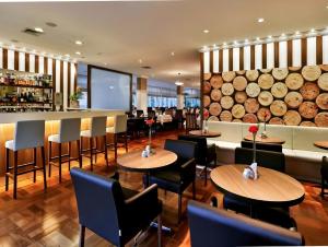 un restaurante con mesas y sillas y un bar en M-Flat II Hotel - Vila Olimpia en São Paulo