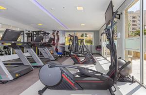 a gym with several treadmills and elliptical machines at M-Flat II Hotel - Vila Olimpia in Sao Paulo
