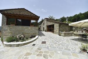 a stone building with a patio and an umbrella at B&B A…Monte in Santa Maria