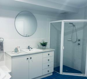 a white bathroom with a sink and a shower at U2 at Moana Beach Esplanade - Exclusive 2 Bdrm Apt - WiFi - Spa - Pet Friendly in Moana