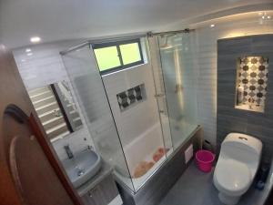 ein Bad mit einer Dusche, einem WC und einem Waschbecken in der Unterkunft Grernhouse in Manizales