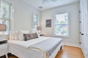 a white bedroom with a large bed and two windows at Downtown Historic Charmer in Saint Augustine