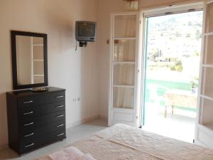 1 dormitorio con 1 cama y vestidor con espejo en Villa Milos en Ayios Nikitas