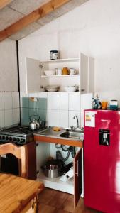 eine Küche mit einem roten Kühlschrank und einer Spüle in der Unterkunft Cabañas Lanco in Panguipulli