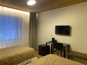 a hotel room with a bed and a desk with a television at Hotelli Heimari in Heimari