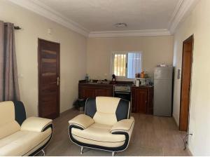 sala de estar con 2 sillas y cocina en Superbe 2pieces avec climatisation en Fatick