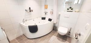 La salle de bains blanche est pourvue d'une baignoire et de toilettes. dans l'établissement Unique, Quiet with Quality - Near the Sea, à Horten