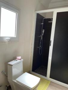 een badkamer met een douche, een toilet en een raam bij Superbe 2pieces avec climatisation in Fatick