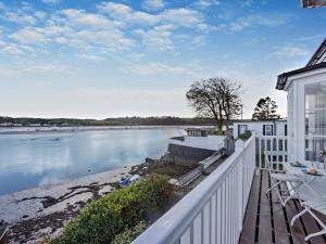 a house with a white fence and a body of water at 3 Bed in Appledore 62597 in Appledore
