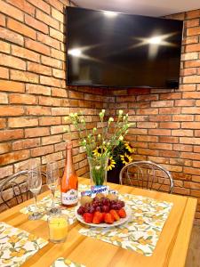 a table with a plate of fruit and a bottle of wine at Mazurski dom Brejdyny Sauna i Bania in Mrągowo