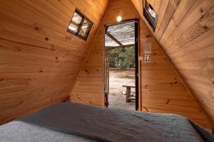 um quarto com uma cama num chalé de madeira em Cabañitas del Bosque em Algarrobo