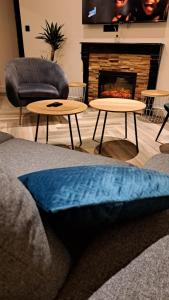 a living room with two tables and a fireplace at L'indigo, 4-6 pers, 2ch-2sdb, proche cité de la gastronomie in Dijon