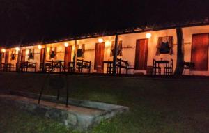 a building with tables and chairs at night at Pouso do Tropeiro - Cavalgadas Roseta in Baependi