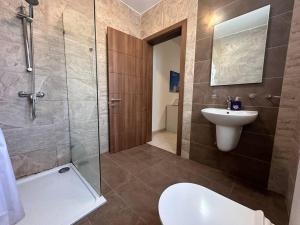 y baño con aseo, lavabo y ducha. en Beautiful Penthouse St Julian's, en San Julián