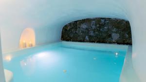 a swimming pool with candles in a room with blue lighting at Blue Cave Oasis with Underground Jacuzzi in Megalokhori