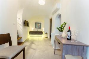 a hallway with a table with wine glasses and a couch at Blue Cave Oasis with Underground Jacuzzi in Megalokhori