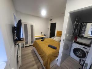a small bedroom with a bed and a washing machine at Lemuria Studio Łokietka in Legnica