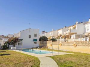 a villa with a swimming pool in front of a building at Apartamento con Terraza en la Playa con Piscina in Cala del Moral