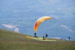 une personne volant un cerf-volant au sommet d'une colline dans l'établissement Locanda della Rocca, à Sarnano