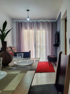 un salon avec une table à manger et un salon avec un canapé dans l'établissement Bem no CENTRO com cozinha completa, varanda e garagem, à Poços de Caldas