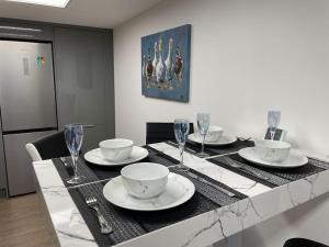 a dining room table with plates and wine glasses at 1 bedroom guesthouse including parking on premises in Braintree