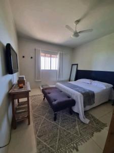 a bedroom with a bed and a table and a tv at Casa do Renato in Anchieta