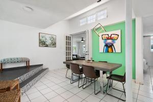 una sala da pranzo con tavolo e parete verde di walk to beach or swim in the pool, 4 bedrooms home a Humacao