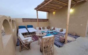 eine Terrasse mit einem Tisch und Stühlen auf einem Gebäude in der Unterkunft WAFLA in Siwa