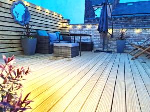 a deck with a bench and an umbrella at Love Lane Villa in Lincoln