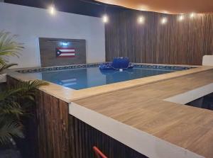 a swimming pool with a blue chair in a room at Pool House by Isla Verde Beach home in San Juan