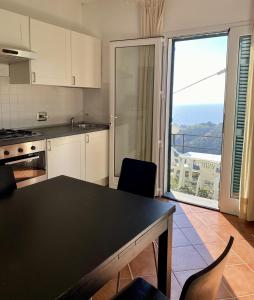 a kitchen with a table and a view of a balcony at Agriturismo L'Ulivo E Il Mare in Moneglia