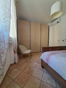sypialnia z łóżkiem, krzesłem i oknem w obiekcie Casa Ulivi e Mare w mieście Ventimiglia