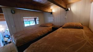 duas camas num quarto com uma parede em Sfeervolle vakantiewoning midden in het Drents-Friese Wold em Wateren