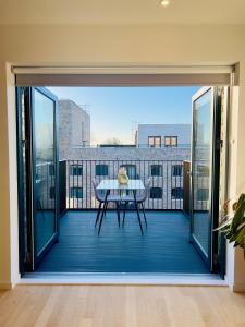 a view of a balcony with a table on a roof at Stylish Brentford Riverside Penthouse in Brentford