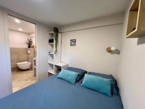 1 Schlafzimmer mit einem blauen Bett und einem Badezimmer in der Unterkunft Studio with private car park and air con in Valbonne