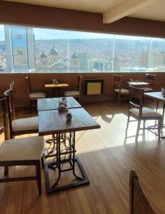 a restaurant with tables and chairs and a large window at Hotel Madrid in La Paz