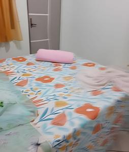 Una cama con una manta con flores. en Pousada Souza Familiar, en Porto Velho