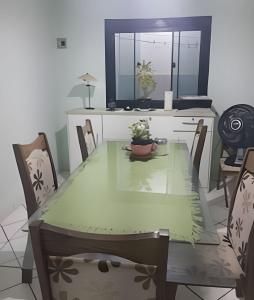 a dining room with a green table and chairs at Pousada Souza Familiar in Porto Velho
