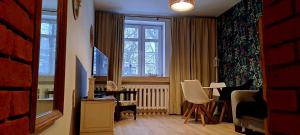 オルシュティンにあるStaszica Starówkaのベッドルーム(テーブル付)1室、窓が備わります。