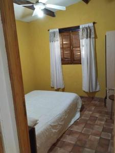 a bedroom with a bed and a ceiling fan at cabañas las moras in La Granja