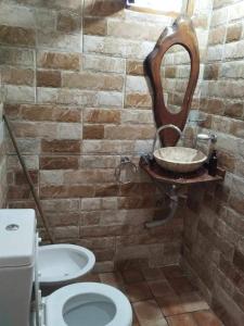 a bathroom with a sink and a toilet and a mirror at cabañas las moras in La Granja +6 photos