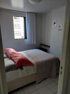 um quarto com uma cama e uma janela em Apart Neo 212 em Maceió