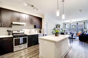 a kitchen with black cabinets and a white counter top at Rooftop Pool with Mountain Views & King Beds with Parking 1123 in Scottsdale