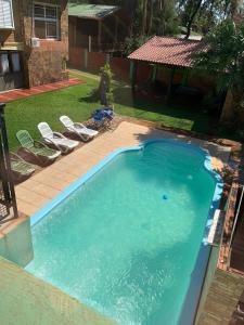 a large swimming pool with chairs in a yard at Apart JM in Puerto Iguazú