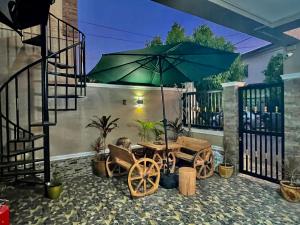 une terrasse avec une table et un parasol dans l'établissement La Maison De Rouch - Lancaster, à General Trias