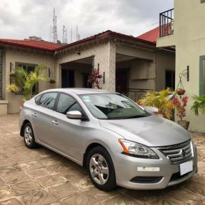 a silver car parked in front of a house at Perriman Hotel in Kokrobite