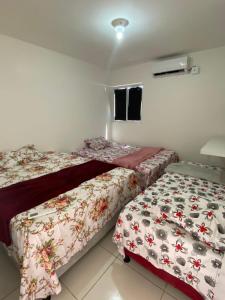2 nebeneinander sitzende Betten in einem Schlafzimmer in der Unterkunft Casa praia do frances in Marechal Deodoro