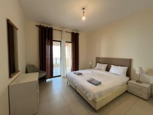 Un dormitorio con una cama grande y una ventana en E13 Samarah Resort Apartment, en Sowayma