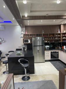 eine Küche mit einer schwarzen Theke und einem Kühlschrank in der Unterkunft Pavillon Luxury in Marrakesch