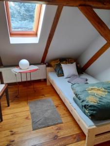 een kleine zolderslaapkamer met een bed en een tafel bij U Joli in Jugowice